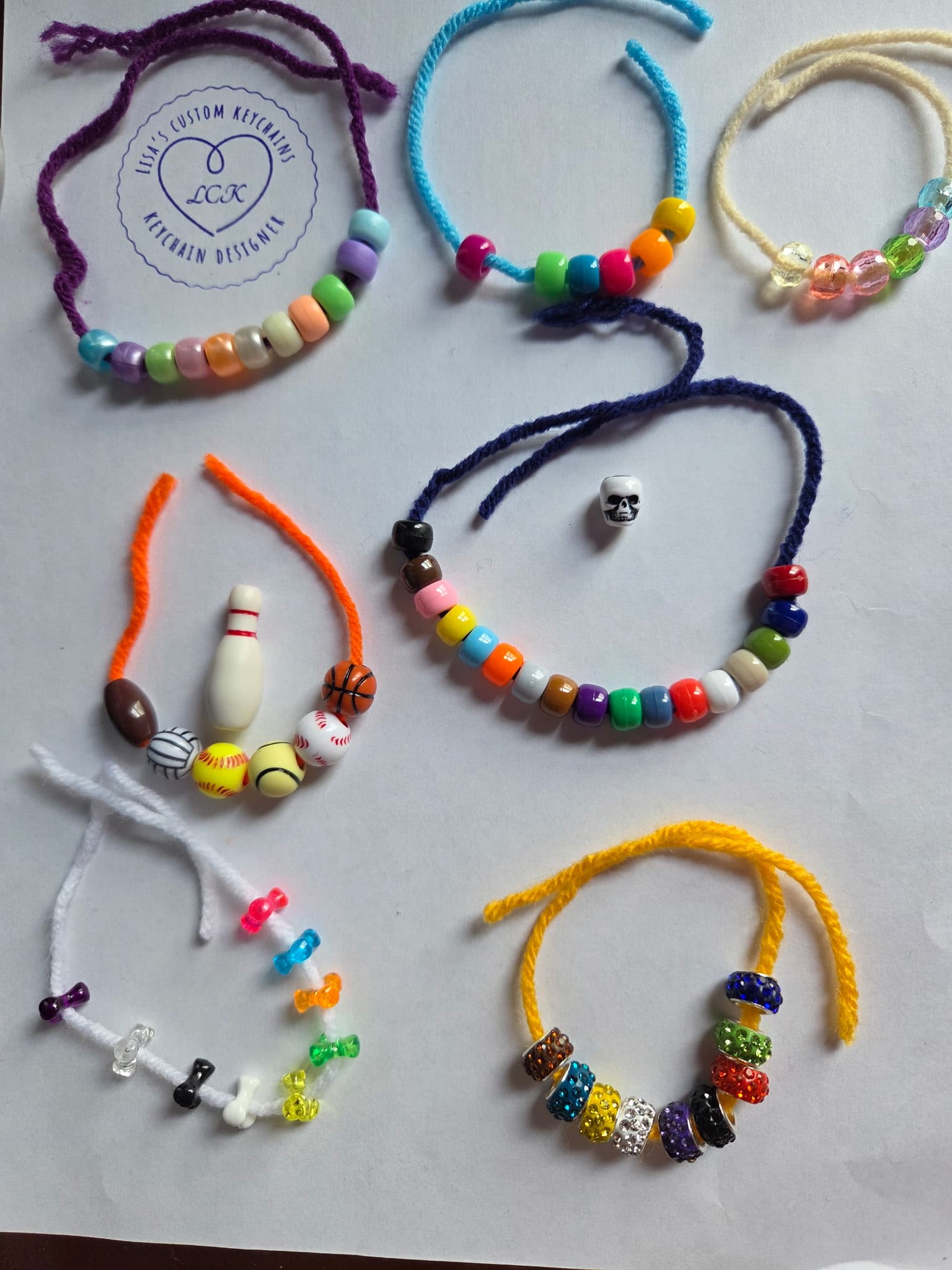 Assorted charm examples including sports beads, colorful bow charms, and sparkle spacer beads
